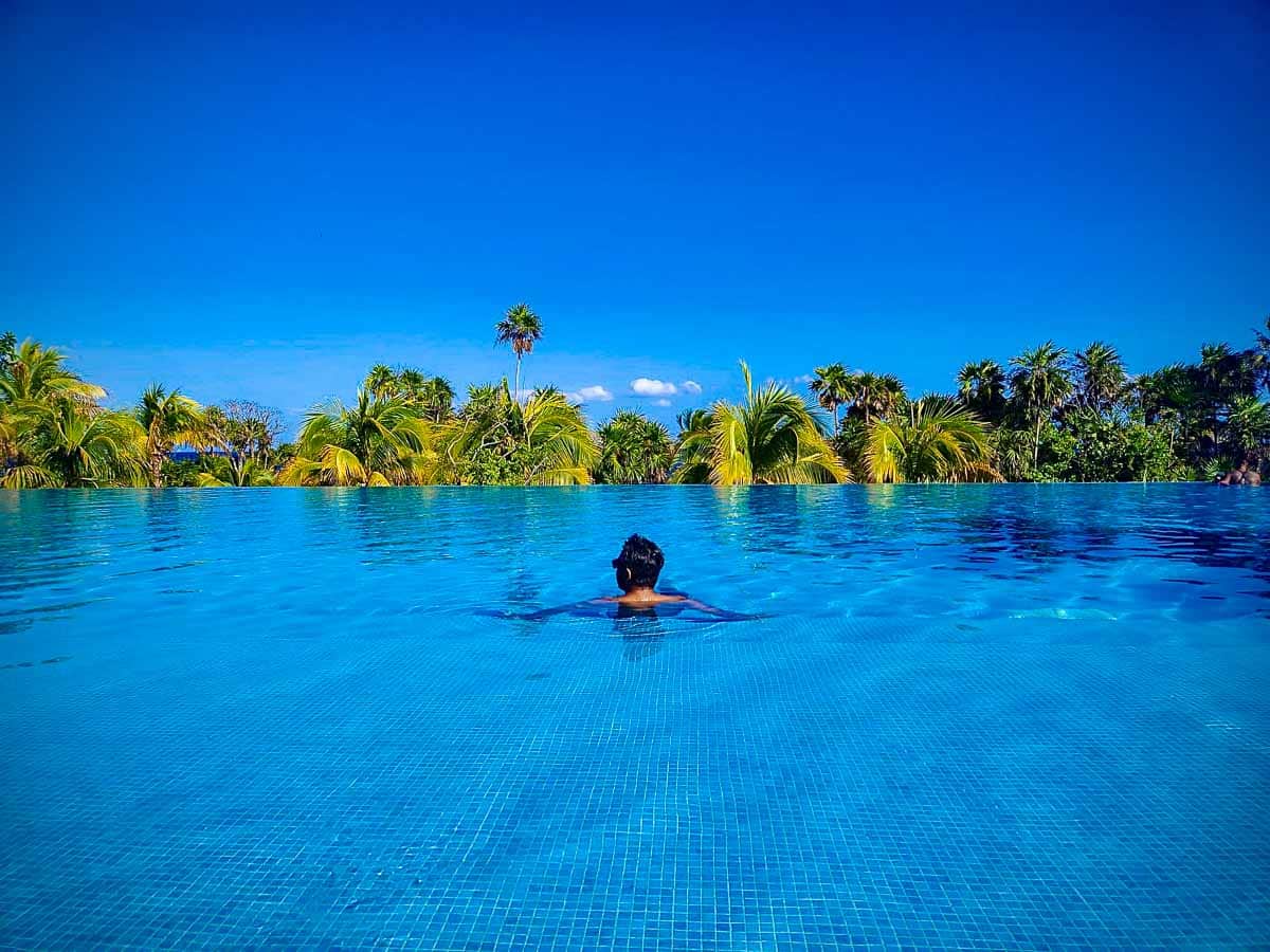 A blue-dominant photo of Riz in Xcaret Arte's main infinity pool.