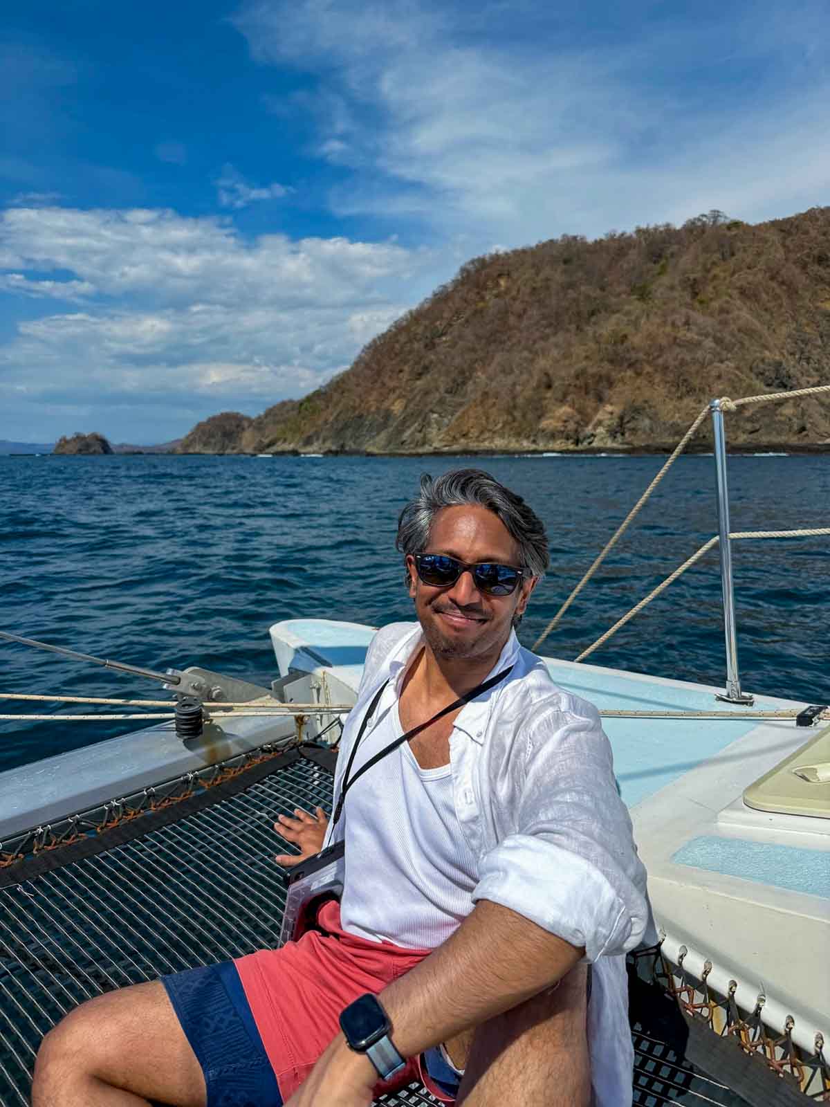Riz smiling while comfortably sitting back on a catamaran in the Pacific Ocean just outside of Tamarindo, Costa Rica.