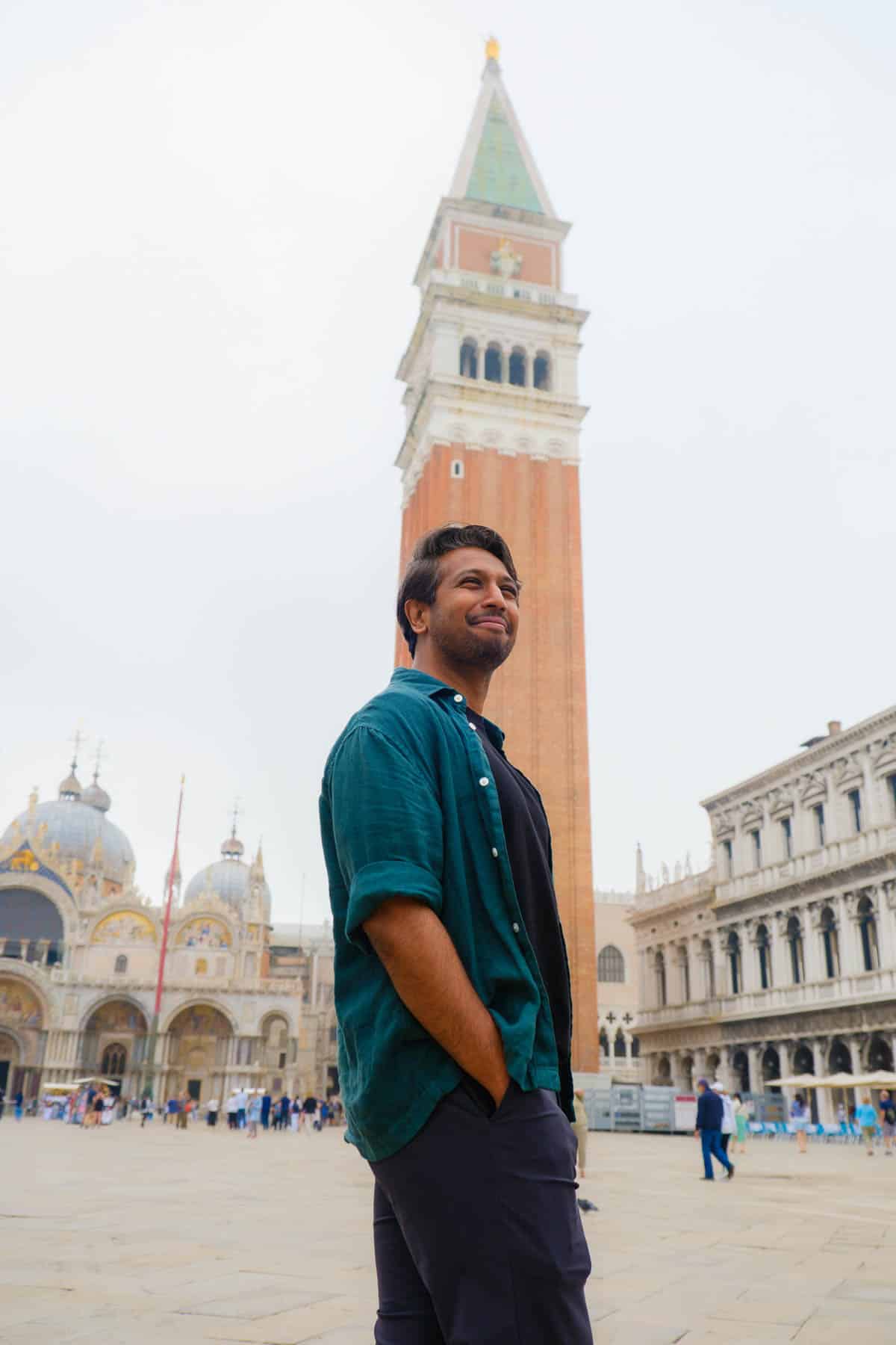 Riz standing in front of the Campinile in St. Mark's Square. The basilica is also visible in the background.