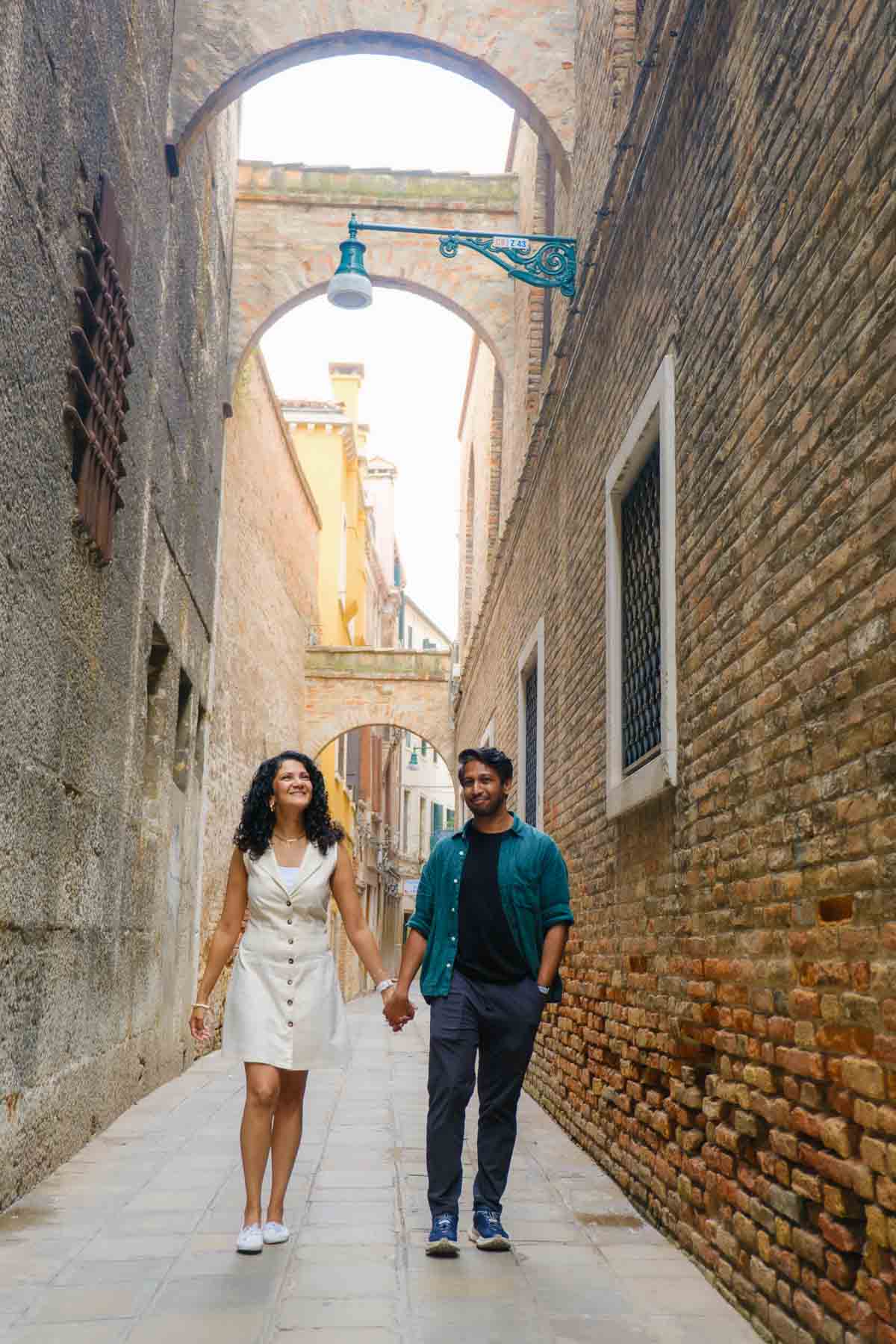 Riz and Reem walking through a narrow street in Venice, Italy.