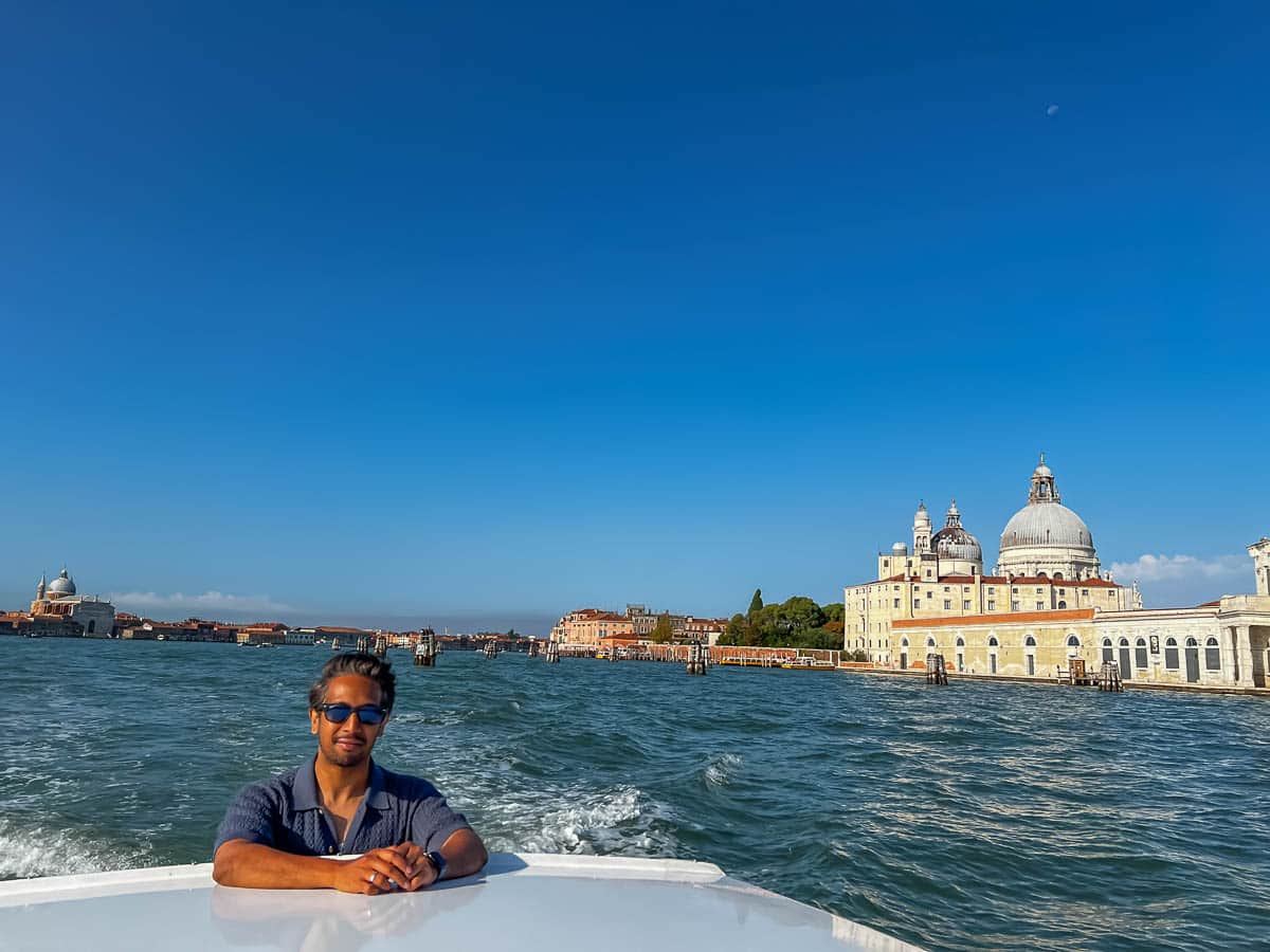 Riz on a private water taxi ride through Venice with Santa Maria della Salute in the background.