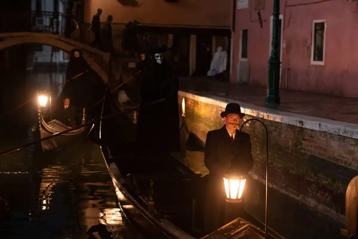 Kenneth Branagh as Hercule Poirot beside a gondola at night in A Haunting in Venice (2023)