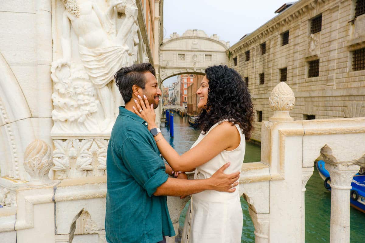 Riz and Reem looking at each other with the Bridge of Sighs, one of Venice's famous filming locations, behind them.