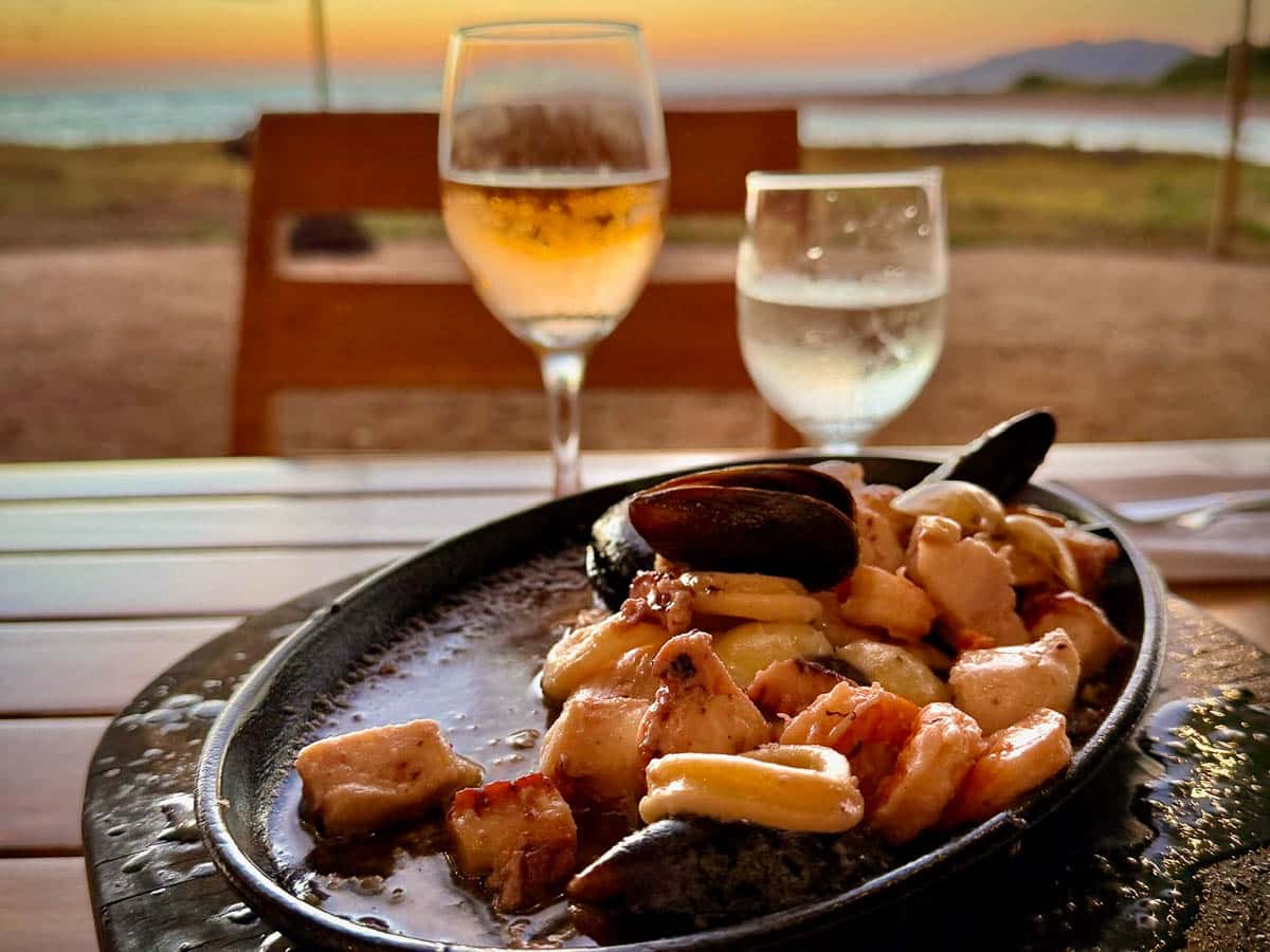 Seafood skillet with shrimp and mussels at Pangas Beach Club overlooking Tamarindo Beach at sunset.