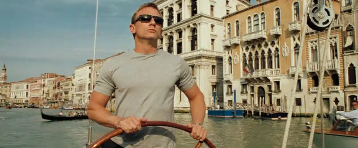James Bond steering a yacht on Venice's Grand Canal